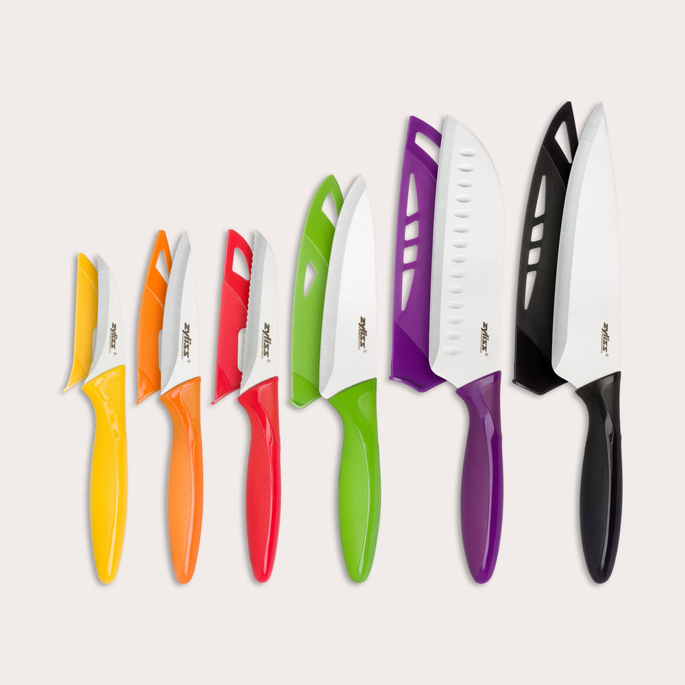 The Zyliss 6 Piece Knife Set includes six kitchen knives with color-coded handles—yellow, orange, red, green, purple, and black—each with a matching sheath for safe food prep. Handles are arranged from smallest to largest on a light background.