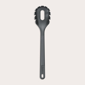 The Zyliss Spaghetti Server is a black, heat-resistant utensil with a long handle and slotted, rounded head featuring prongs for ideal portion control, shown isolated on a light background.