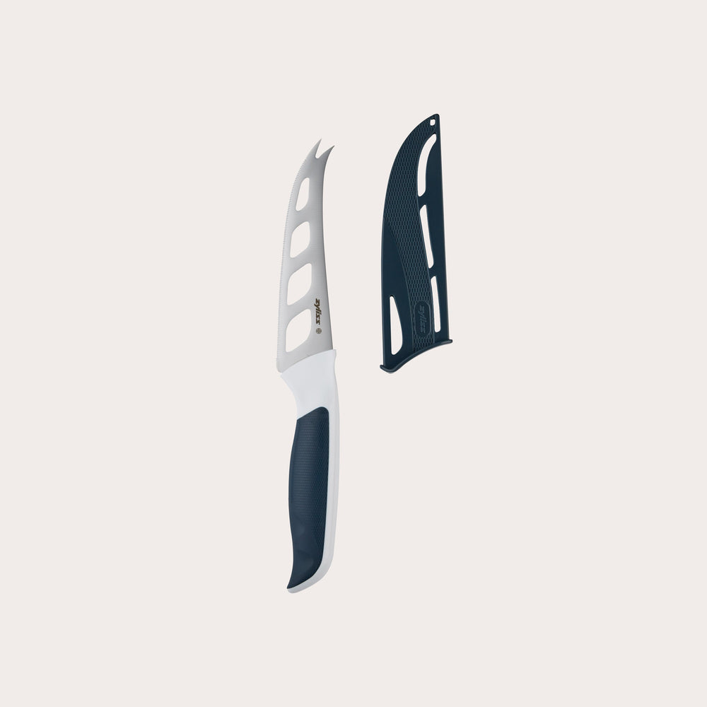The Zyliss Comfort Cheese Knife 12cm / 4¾, with an ergonomic handle, partially serrated blade with large cut-out holes, and matching black blade cover, is placed beside it on a plain light background.