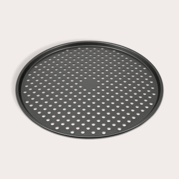 The Zyliss Non-Stick Pizza Tray is a round, black, carbon steel tray featuring numerous evenly spaced holes for crispy pizza bases. Shown on a white background.