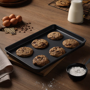 Freshly baked cookies rest on a Zyliss Non-Stick Baking Tray, designed from carbon steel for even heat distribution.