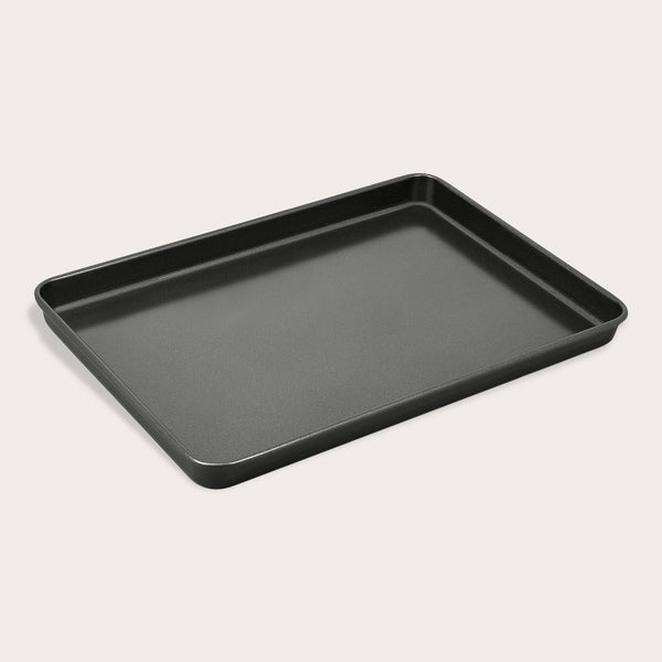 The Zyliss Non-Stick Baking Tray is a black, rectangular carbon steel pan with slightly raised edges for even heat distribution, shown against a plain white background.