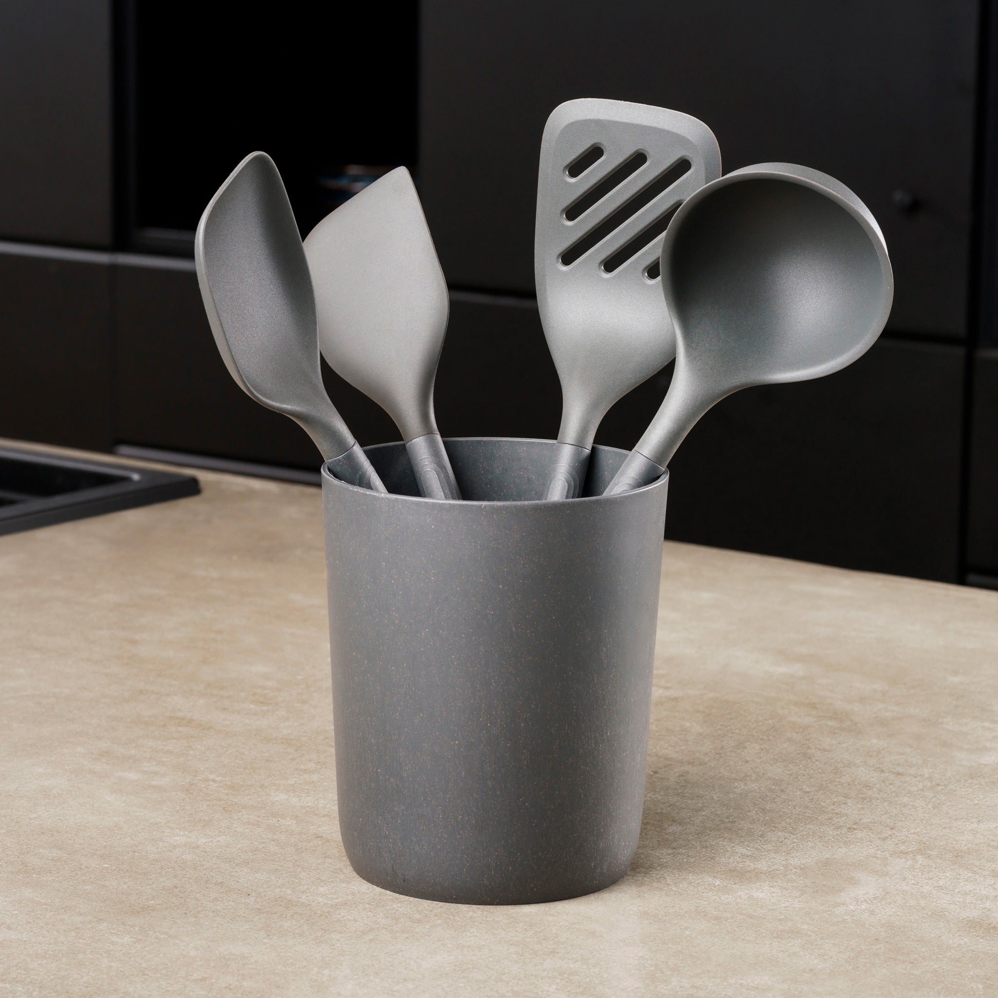 The Zyliss 5-Piece Utensil Set includes four gray kitchen tools—spatula, slotted spatula, ladle, and spoon—in a matching holder. Dishwasher safe and ideal for any modern kitchen.