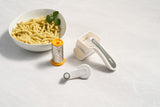 A bowl of pasta and a Zyliss Classic Cheese Grater on a kitchen counter